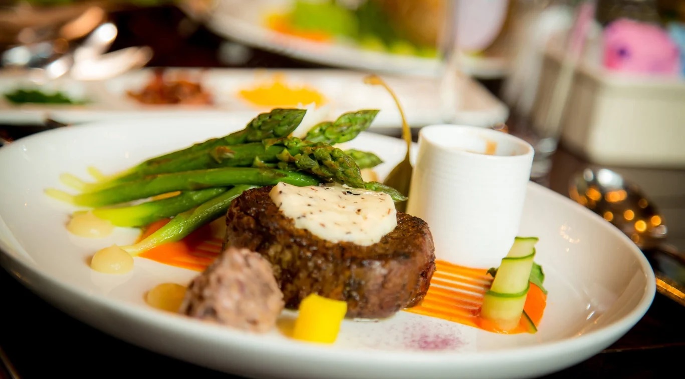 Image of Steak Entrée served alongside veggies and sauce in The Main Dining Room. Grand Hotel, a member of Historic Hotels since 2001, dates to 1886. It is located in Mackinac Island, Michigan.
