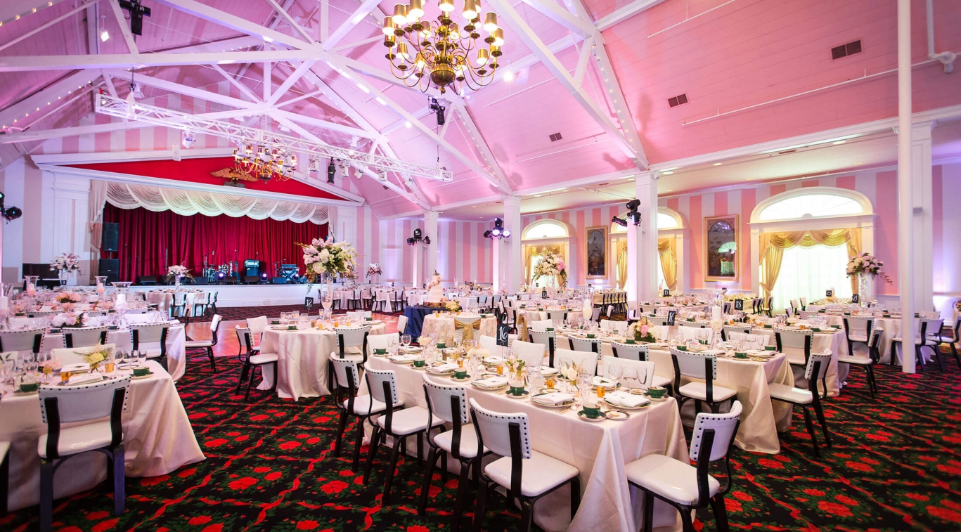 Image of wedding taking place in the Theatre with pink hues and band set on stage. Grand Hotel, a member of Historic Hotels since 2001, dates to 1886. It is located in Mackinac Island, Michigan.