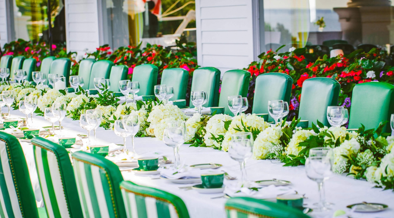Image of a luncheon wedding reception taking place with table decorated and fresh flowers put out. Grand Hotel, a member of Historic Hotels since 2001, dates to 1886. It is located in Mackinac Island, Michigan.