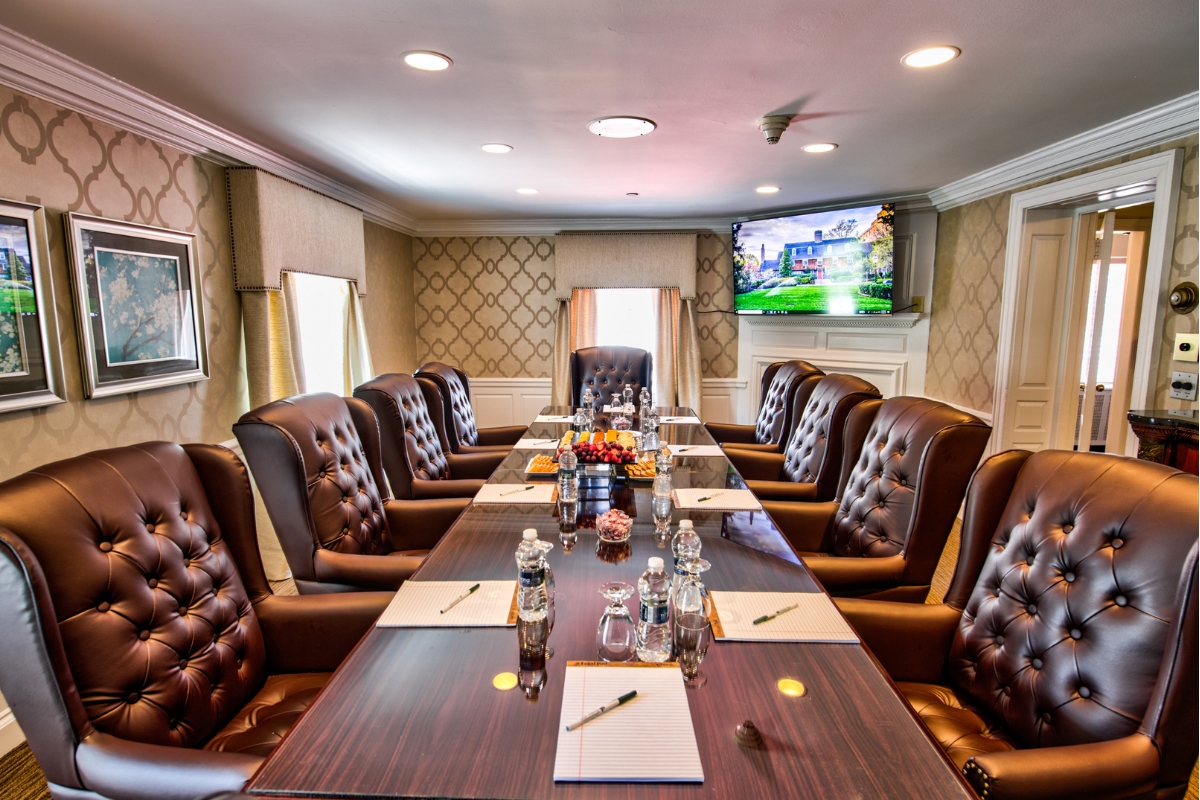 Image of the General Mercer Boardroom at The Nassau Inn (1756), a member of Historic Hotels of America since 2024. Pictured is a conference table set for a meeting and surrounded by leather armchairs.