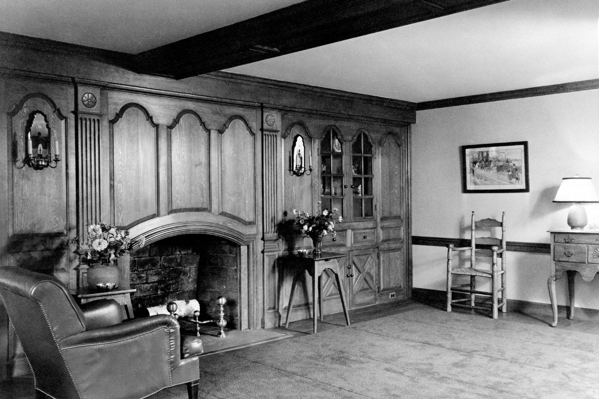 Historic image of the lobby at The Nassau Inn (1756), a member of Historic Hotels of America since 2024. Pictured are a fireplace and armchair in a wood-paneled room.