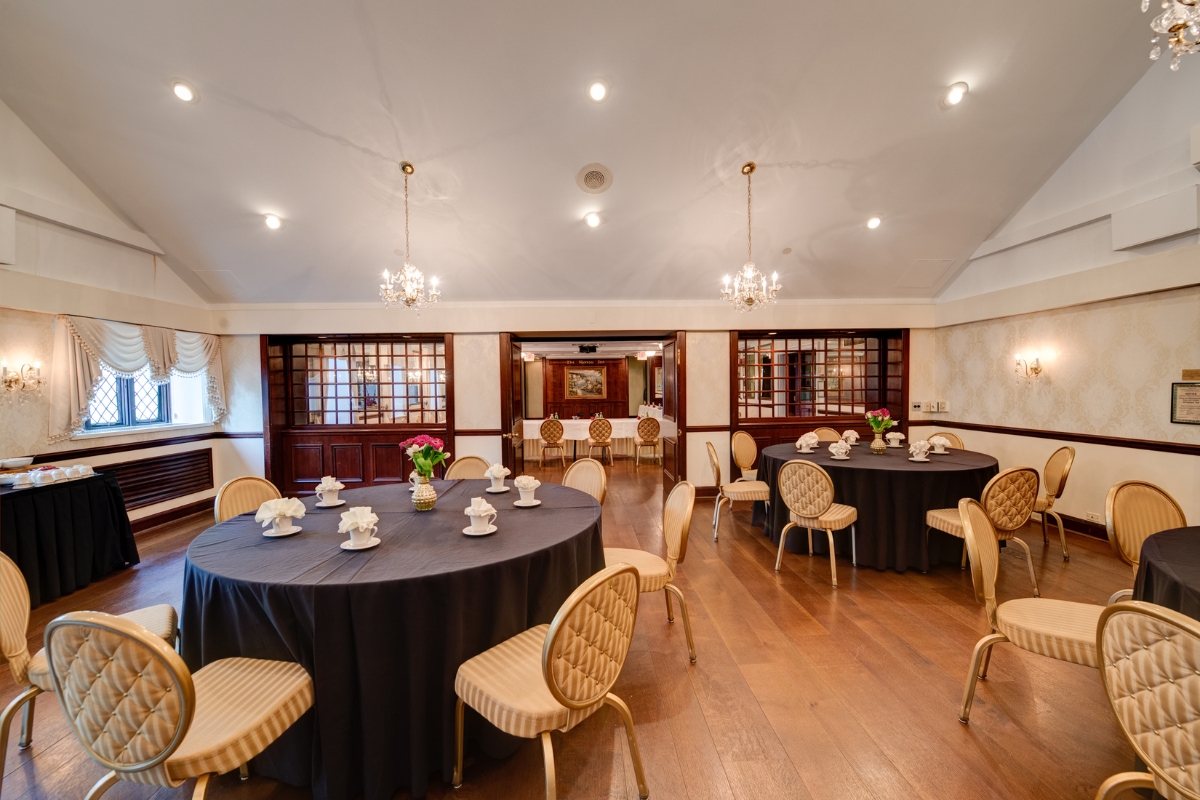 Image of the John Witherspoon Room at the Nassau Inn (1756) a member of Historic Hotels of America since 2024. Pictured are several set tables with chairs.
