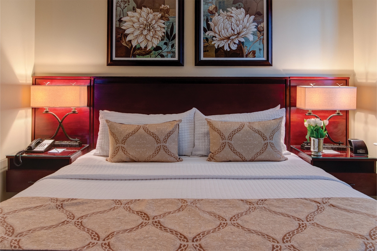Image of a king room at The Nassau Inn (1756), a member of Historic Hotels of America since 2024. Pictured is a large bed with other bedroom furnishings and decor.