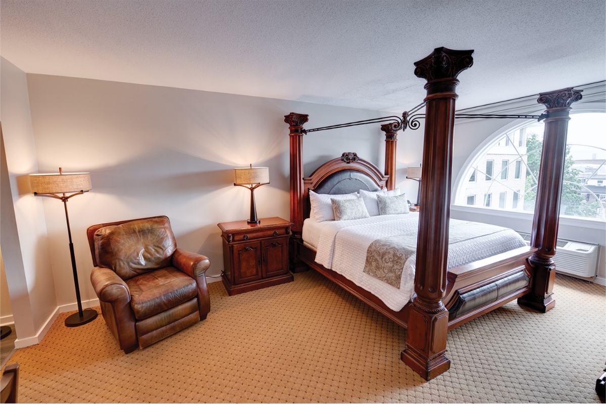 Image of the Norman Rockwell Suite at The Nassau Inn (1756), a member of Historic Hotels of America since 2024. Pictured is a large four-poster bed and armchair.