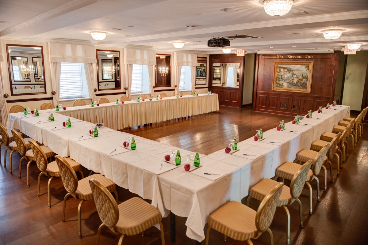 Image of the Palmer Room at The Nassau Inn (1756), a member of Historic Hotels of America since 2024. Pictured is a large array of set conference tables.