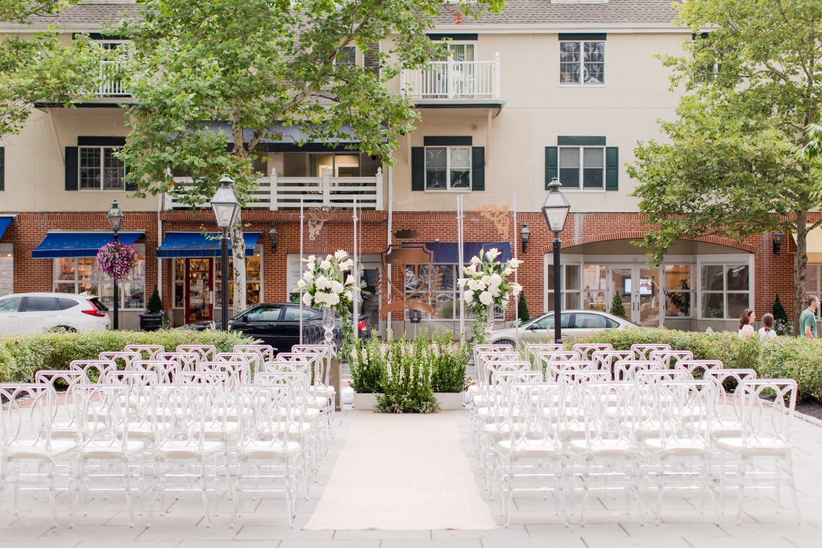 Image of a patio at The Nassau Inn (1756), a member of Historic Hotels of America since 2024. Pictured is an outdoor space set with rows of chairs and other decor for a wedding.