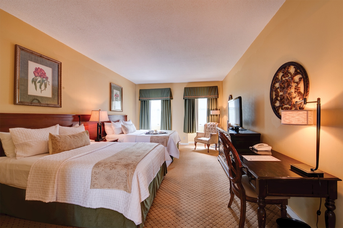 Image of a two queen room at The Nassau Inn (1756), a member of Historic Hotels of America since 2024. Pictured are two large beds and a nightstand.