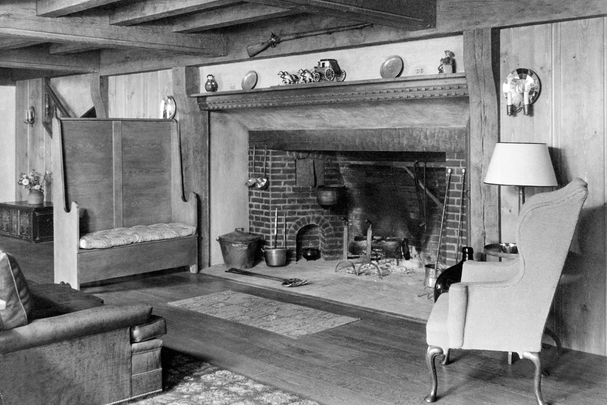 Historic image of the original hearth at the Nassau Inn (1756) a member of Historic Hotels of America since 2024. Pictured are several seating options around a large hearth with pots.