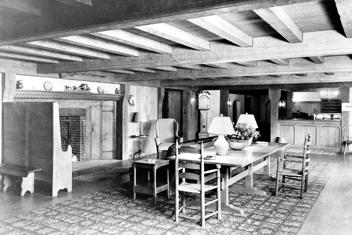 Historic image of the original tavern at the Nassau Inn (1756) a member of Historic Hotels of America since 2024. Pictured are tables and chairs and a large hearth.