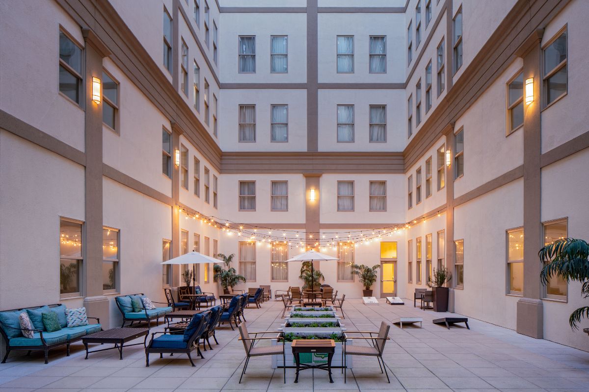 Image of the courtyard at Hilton Richmond Downtown (1885), a member of Historic Hotels of America since 2024. Pictured is a spacious courtyard with colorful outdoor furniture.
