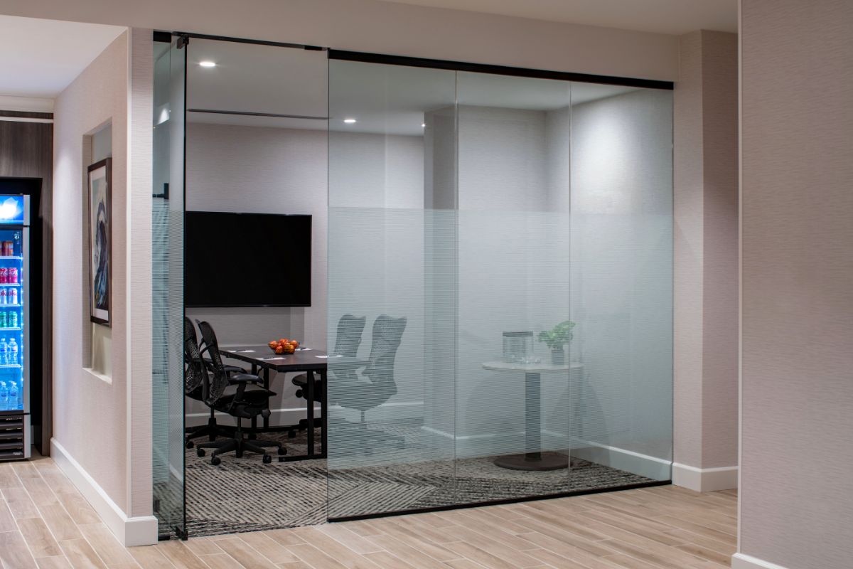 Image of a meeting room at Hilton Richmond Downtown (1885), a member of Historic Hotels of America since 2024. Pictured is a glass cubicle with a conference table and chairs.