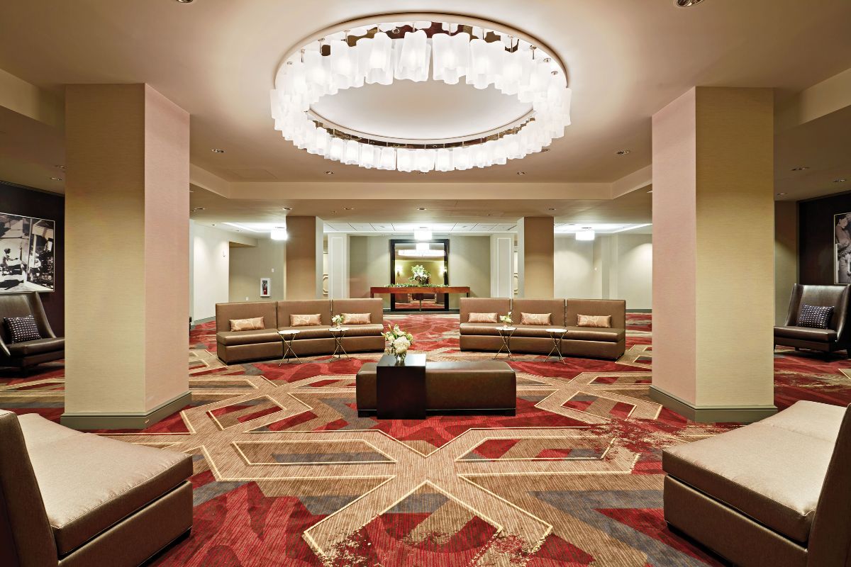 Image of events space at Hilton Richmond Downtown (1885), a member of Historic Hotels of America since 2024. Pictured is a room with couches and an elaborate carpet.