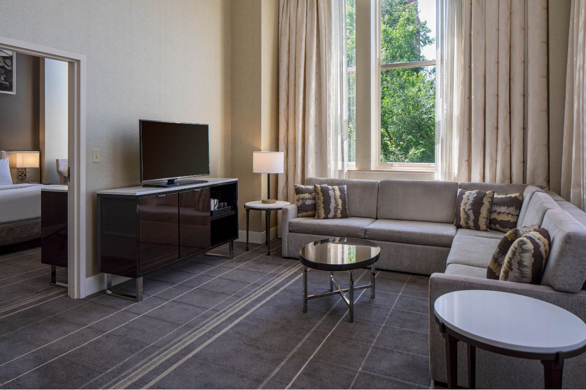 Image of a suite at Hilton Richmond Downtown (1885), a member of Historic Hotels of America since 2024. Pictured is a living area with a couch and other furniture.